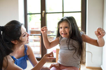 Porträt einer Mutter und eines wütenden kleinen Mädchens zu Hause, Konzept eines Wutanfalls. - HPIF15947
