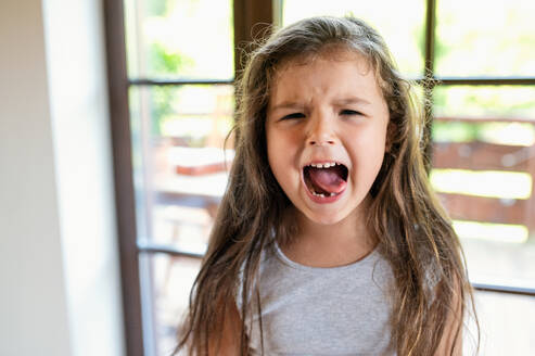 Portrait of angry and difficult small girl indoors, crying. - HPIF15952