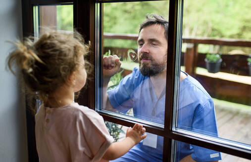 Der Arzt kommt, um seine Tochter in der Isolation zu sehen und zu begrüßen, die Fensterscheibe trennt sie. - HPIF15980