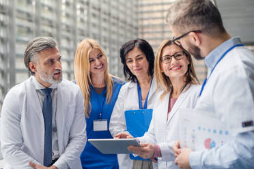 Eine Gruppe von Ärzten auf einer Konferenz, ein medizinisches Team steht und diskutiert Fragen. - HPIF16013