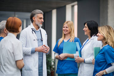 Eine Gruppe von Ärzten steht in einem Krankenhauskorridor auf einer medizinischen Konferenz. - HPIF16046