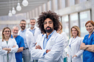 Eine Gruppe von Ärzten steht auf einem Korridor bei einer medizinischen Konferenz und schaut in die Kamera. - HPIF16069