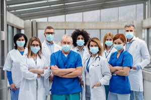 A group of doctors with face masks looking at camera, corona virus concept. - HPIF16079