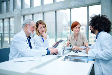 Eine Gruppe von Ärzten mit Laptop auf einer Konferenz, ein medizinisches Team bespricht Probleme. - HPIF16093