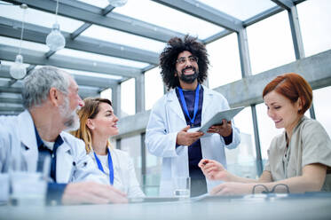 A group of doctors with tablet on conference, medical team discussing issues. - HPIF16094