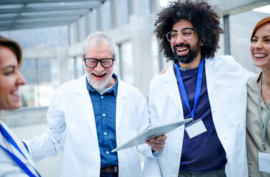 Group of doctors with tablet on conference, medical team laughing when discussing issues. - HPIF16112