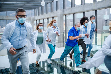 Eine Gruppe von Ärzten läuft eilig durch den Korridor eines Krankenhauses, Notfallkonzept. - HPIF16168