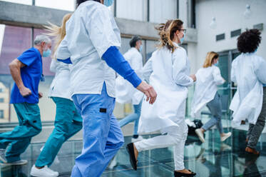 Eine Gruppe von Ärzten läuft eilig durch den Korridor eines Krankenhauses, Notfallkonzept. - HPIF16170