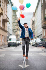 Glücklicher älterer Mann mit Luftballons im Freien auf der Straße in der Stadt, zu Fuß. Party-Konzept. - HPIF16240