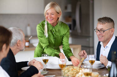 Eine Gruppe älterer Freunde genießt eine Dinnerparty zu Hause. - HPIF16267
