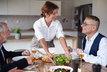 Eine Gruppe älterer Freunde genießt eine Dinnerparty zu Hause. - HPIF16269