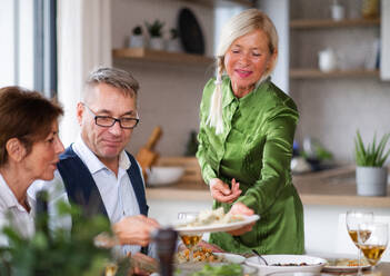 Eine Gruppe älterer Freunde genießt eine Dinnerparty zu Hause. - HPIF16274