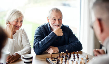 Eine Gruppe glücklicher älterer Freunde, die zu Hause Brettspiele spielen. - HPIF16287