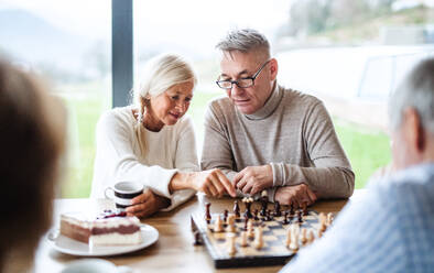 Group of happy senior friends at home, playing board games. - HPIF16290