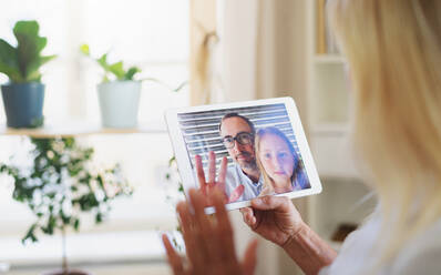 Happy senior woman with laptop indoors at home, family video call concept. - HPIF16336