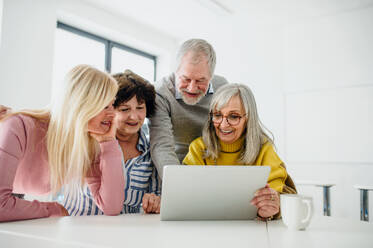 Eine Gruppe fröhlicher älterer Menschen, die einen Computer- und Technologiekurs besuchen. - HPIF16390