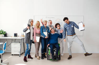 Eine Gruppe fröhlicher älterer Menschen, die einen Computer- und Technologiekurs besuchen. - HPIF16416