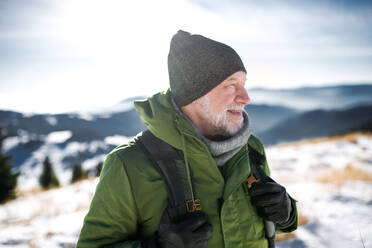 Porträt eines älteren Mannes in verschneiter Winternatur in der Vorderansicht. - HPIF16499