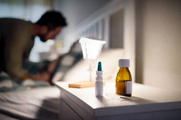 Flasche mit Medikamentensirup und Nasenspray auf dem Nachttisch zu Hause, Medizin- und Krankheitskonzept. - HPIF16553