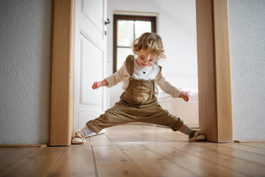 Vorderansicht eines kleinen Kleinkindes, das zu Hause steht und Spaß hat. - HPIF16584