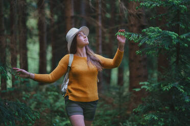 Front view of young woman on a walk outdoors in forest in summer nature, walking. - HPIF16614