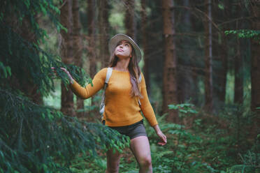 Front view of young woman on a walk outdoors in forest in summer nature,  walking. stock
