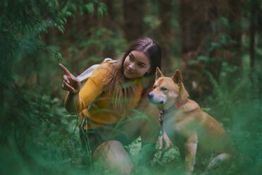 Happy young woman with a dog on a walk outdoors in summer nature. - HPIF16619