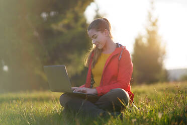Seitenansicht der glücklichen jungen Frau mit Laptop im Sommer Natur, Outdoor-Büro-Konzept. - HPIF16630