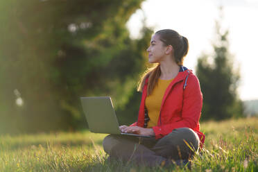 Seitenansicht der glücklichen jungen Frau mit Laptop im Sommer Natur, Outdoor-Büro-Konzept. - HPIF16631