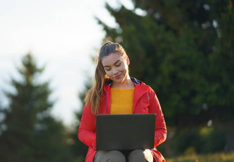 Frontansicht der glücklichen jungen Frau mit Laptop im Sommer Natur, Outdoor-Büro-Konzept. - HPIF16634