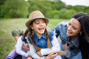 Happy family with two small daughters having fun outdoors in spring nature, playing. - HPIF16789