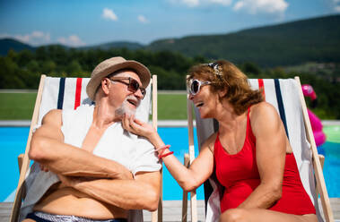 Fröhliches, verliebtes älteres Paar am Swimmingpool im Hinterhof. - HPIF16829