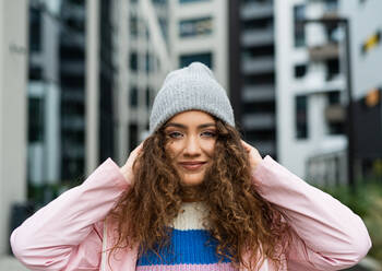 Porträt einer jungen Frau im Freien auf der Straße, die in die Kamera schaut. - HPIF16949