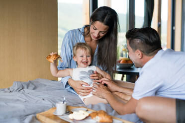 Junge Familie mit kleiner Tochter beim Frühstück im Haus, Wochenendausflug im Containerhaus auf dem Land. - HPIF16958