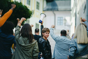 Porträt einer jungen Frau mit Megaphon, die auf der Straße protestiert, Streik- und Demonstrationskonzept. - HPIF17051