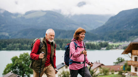 Ein älteres Rentnerpaar mit Nordic-Walking-Stöcken beim Wandern in der Natur. - HPIF17145