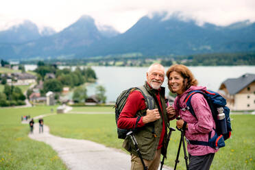 Ein älteres Rentnerpaar mit Nordic-Walking-Stöcken beim Wandern in der Natur, stehend. - HPIF17154