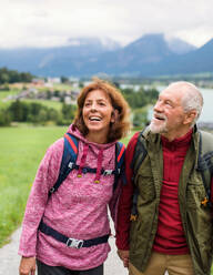 Frontansicht eines glücklichen Rentnerpaares beim Wandern in der Natur, das sich unterhält. - HPIF17162