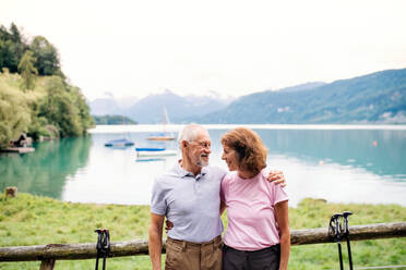 A senior pensioner couple hikers standing in nature, resting. Copy space. - HPIF17178