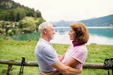 A happy senior pensioner couple hikers in love standing in nature, resting. - HPIF17179