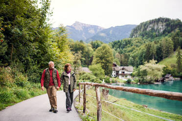 Ein aktives Rentnerpaar wandert in der Natur und hält sich an den Händen. - HPIF17201