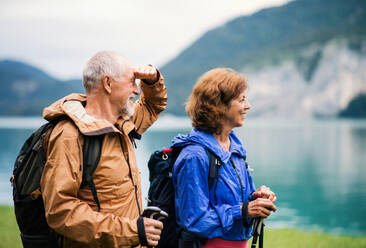 Ein älteres Rentnerpaar, das am See in der Natur wandert und sich ausruht. - HPIF17213