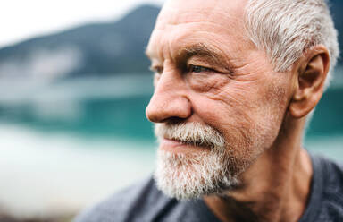 A close-up portrait of senior man pensioner standing outdoors in nature. Copy space. - HPIF17241