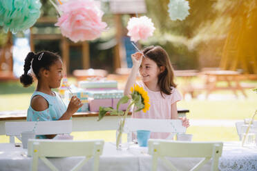 Kleine Mädchen im Gespräch im Freien im Garten im Sommer, eine Geburtstagsfeier Konzept. - HPIF17562