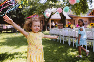 Kleines Mädchen läuft im Freien im Garten im Sommer, eine Geburtstagsfeier Konzept. - HPIF17563