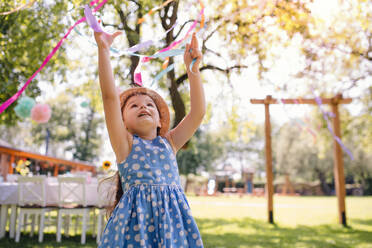 Kleines Mädchen steht im Freien im Garten im Sommer, eine Geburtstagsfeier Konzept. - HPIF17565