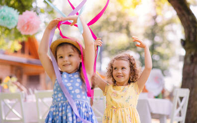 Kleine Mädchen spielen im Freien im Garten im Sommer, eine Geburtstagsfeier Konzept. - HPIF17570