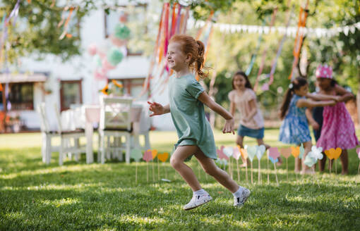Kleine Kinder, die im Sommer draußen im Garten rennen und spielen - ein Konzept für ein Fest. - HPIF17623
