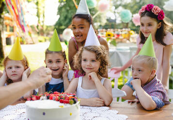 Down-Syndrom-Kind mit Freunden auf Geburtstagsfeier im Freien im Garten im Sommer. - HPIF17647