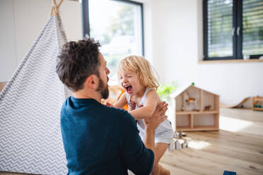 Eine junge Familie mit einem kleinen Kind, das sich im Schlafzimmer vergnügt. - HPIF17754